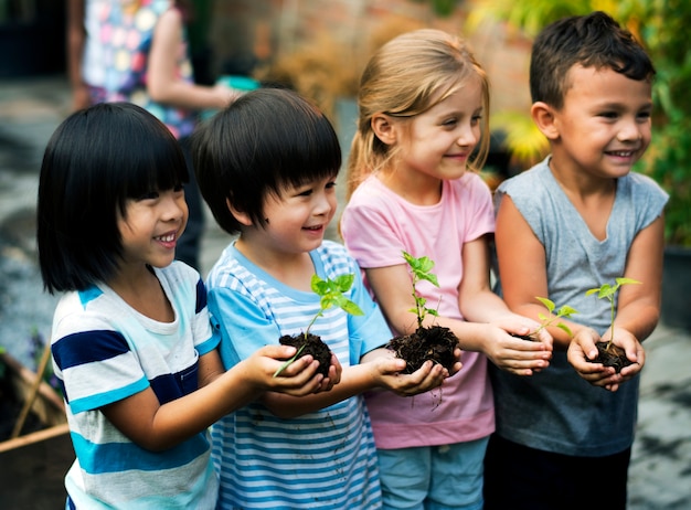 Group of diverse kids holding plants