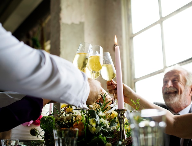 Gruppo di persone diverse tintinnio di bicchieri di vino insieme