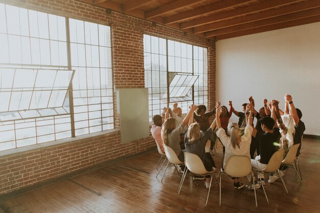 Group of diverse people holding hands up in the air