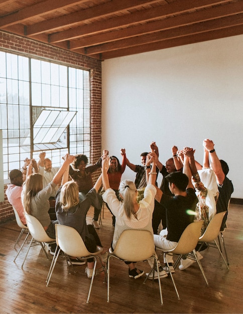 Group of diverse people holding hands up in the air