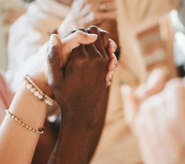 Group of diverse people holding hands up in the air