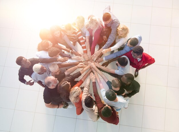 Group of diverse people standing in a circle and joining their palms together