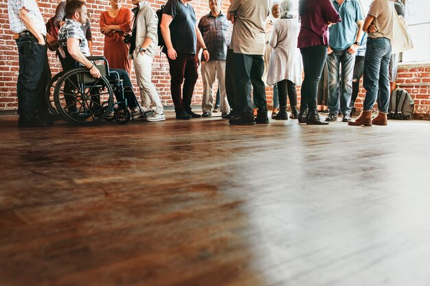 Gruppo di persone diverse in piedi davanti a un muro di mattoni