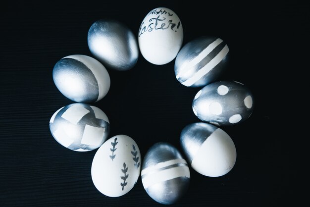 Группа разнообразных серебряных пасхальных яиц на черном фоне, оригинальная стильная идея, избирательный подход