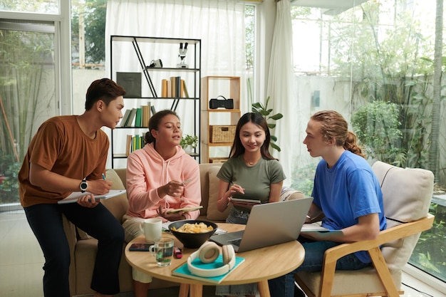 group of diverse teenagers gathered at home to discuss school project