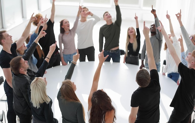 Group of diverse young people applaud standing around a round\
ta