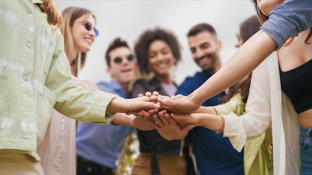 Group of diverse  young people joining hands in a stack. Cooperation, unity and cooperation concept.