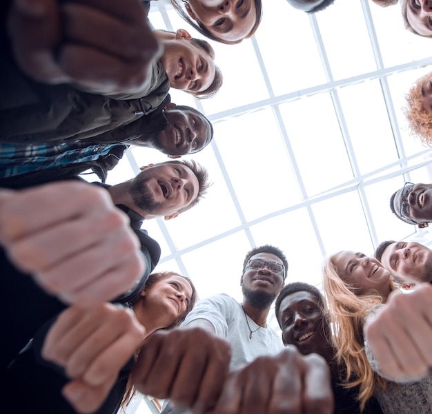 Group of diverse young people joining their hands in a ring