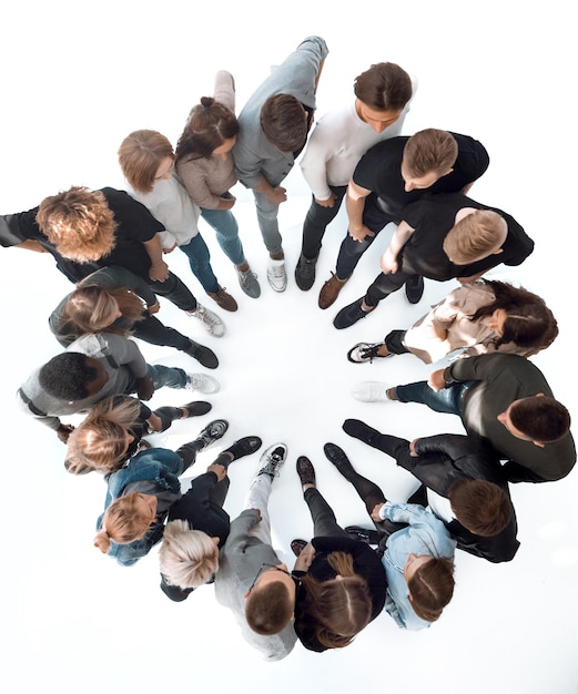 Photo group of diverse young people standing in a circle and looking down