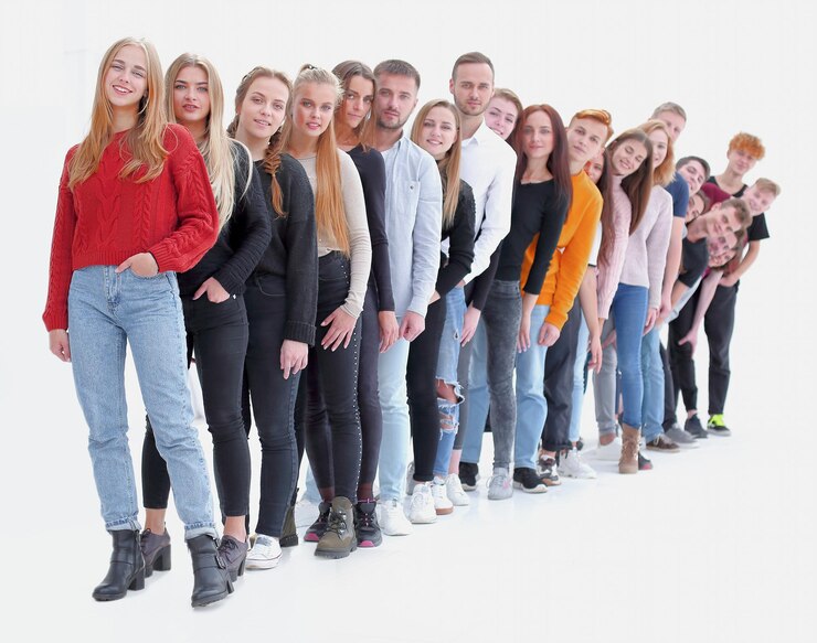 Фотография группа разнообразных молодых людей, стоящих в очереди.