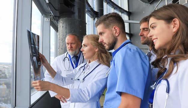 Gruppo di medici che controllano i raggi x in un ospedale.