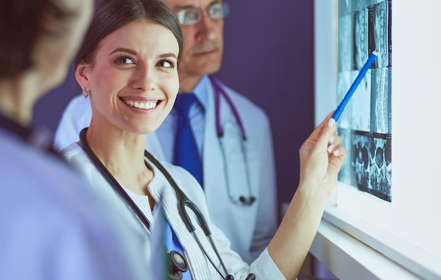 Group of doctors examining x-rays in a clinic, thinking of a diagnosis