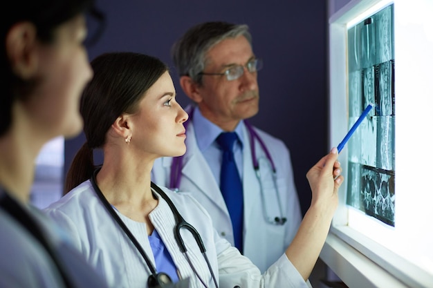 Group of doctors examining xrays in a clinic thinking of a diagnosis