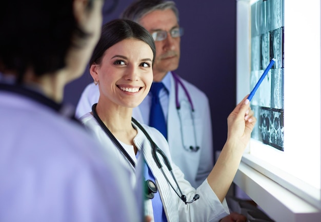 Group of doctors examining xrays in a clinic thinking of a diagnosis