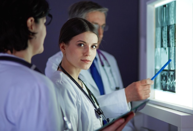 Group of doctors examining xrays in a clinic thinking of a diagnosis