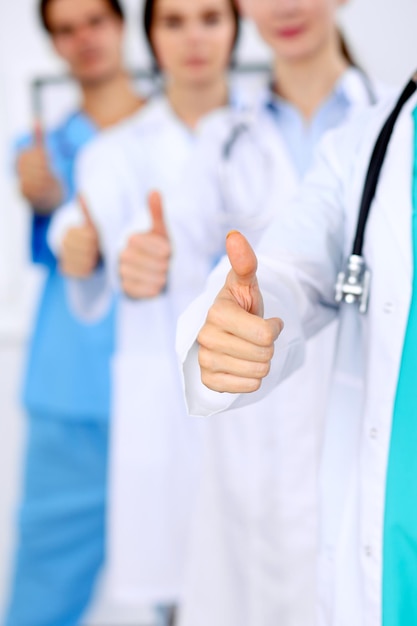 Group of doctors showing OK or approval sign with thumb up. High level and quality medical service, best treatment and patient care concept.