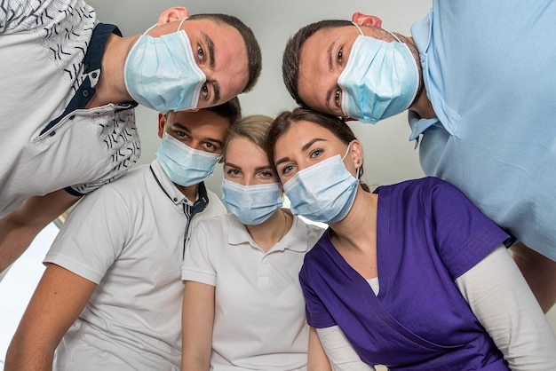 Group of doctors standing in a circle with medical instruments all looking down on patient