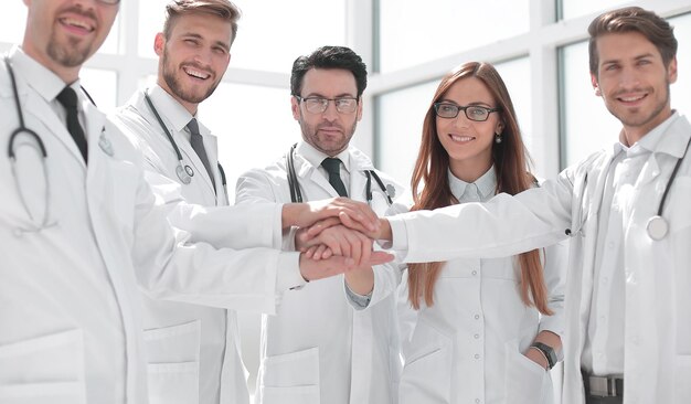 Group of doctors with their hands folded togetherthe concept of health