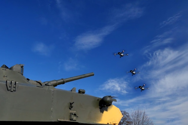 A group of drones on the background of a bare sky next to a tank aerial reconnaissance