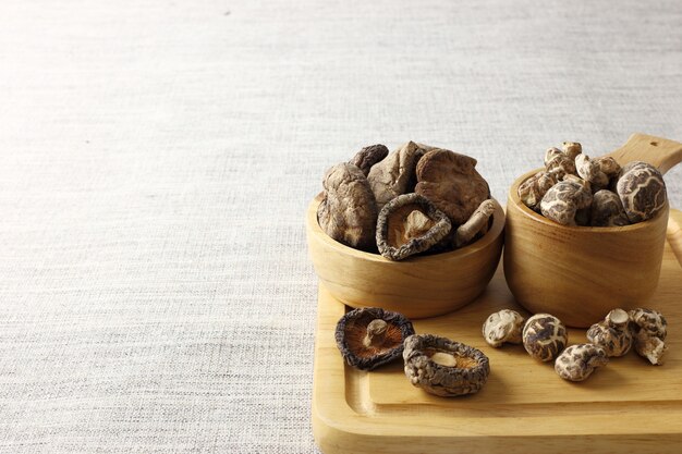 Group of dry Shiitake mushrooms against fabric texture