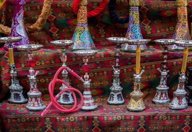 Group of eastern hookahs placed of various colors on a shelf