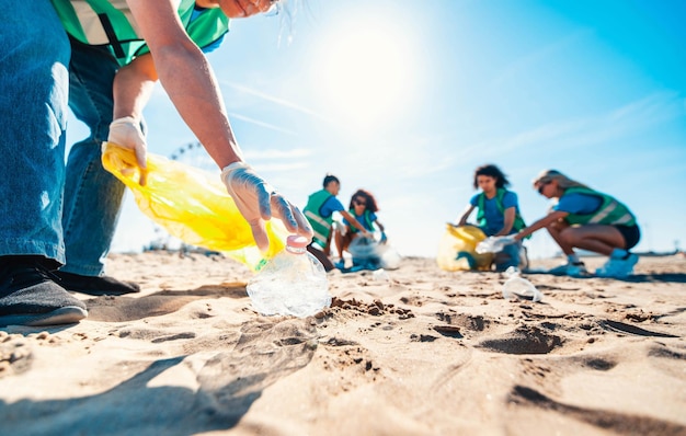 Group of eco volunteers picking up plastic trash on the beach