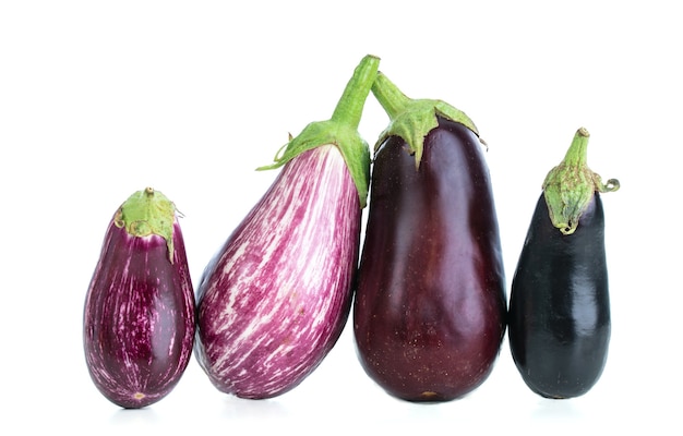 Group of eggplants of different colors cut out on a white surface