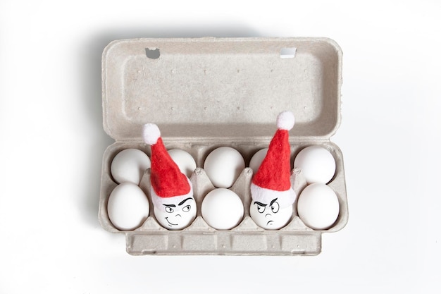 Group of eggs in toy christmas hats with drawn emotions