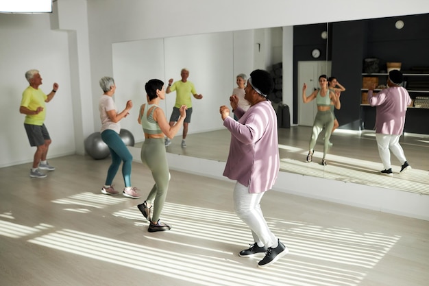 Group of elderly people dancing together in gym