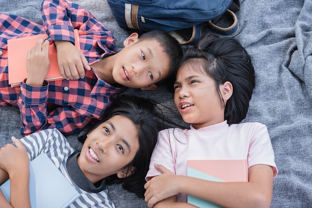 Group elementary school children talk while lying on the blanket