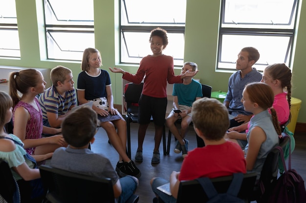 Photo group of elementary school kids sitting in a circle