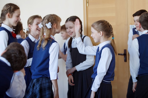 Foto gruppo di bambini delle scuole elementari in piedi nel corridoio della scuola