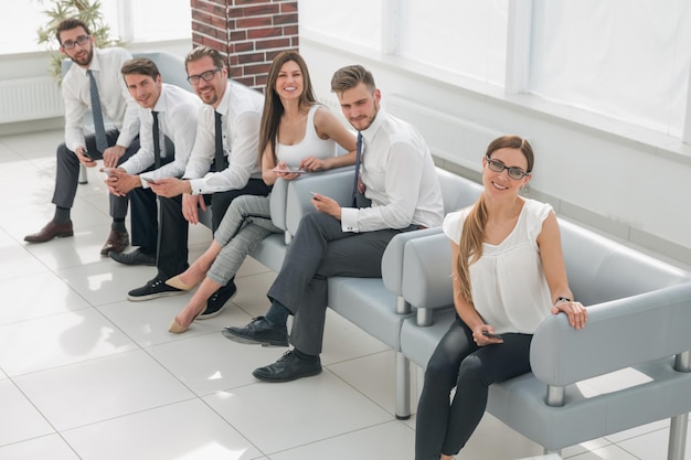 현대적인 사무실 비즈니스 개념의 로비에 앉아 있는 직원 그룹