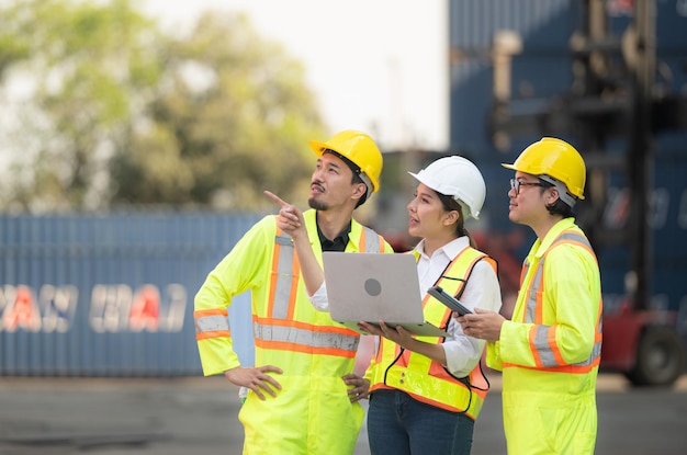 Group of engineers working with laptop in the container yard