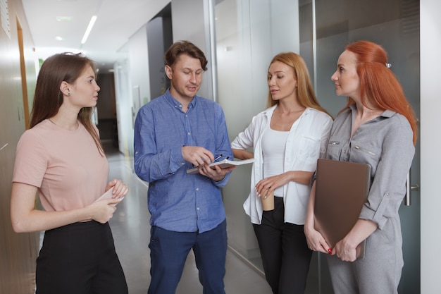 Group of entrepreneurs talking on the corridor at their workplace