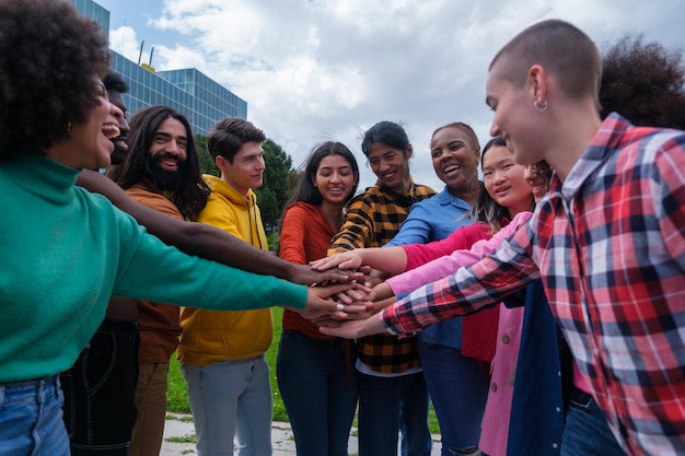 Foto gruppo di giovani etnicamente diversi che uniscono le mani