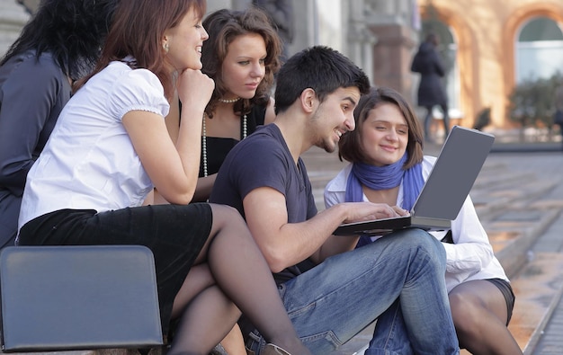 Group of fellow students with books and laptop