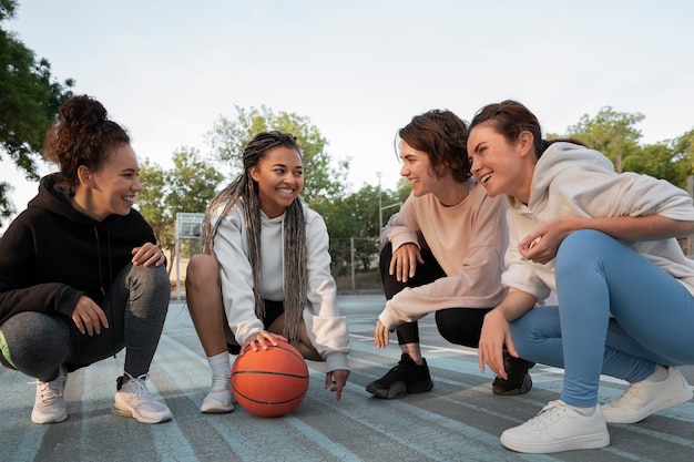 Photo group of female friends playing basketball