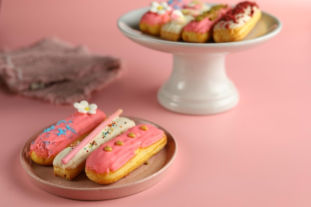 Group of Fench delicious dessert Eclair with pink color on pink background for Valentine concept