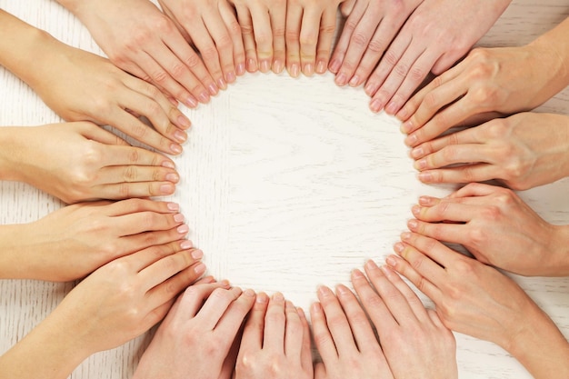 Photo group of fingers forming circle on wooden background