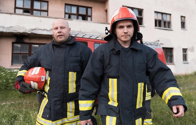 Group of fire fighters standing confident after a well done rescue operation. Firemen ready for emergency service. High quality photo