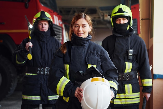 Gruppo di vigili del fuoco in uniforme protettiva che si trova in stazione