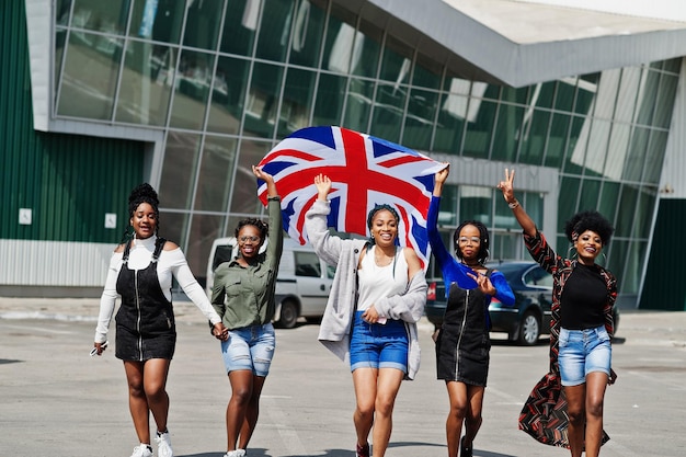 Group of five african american woman walking together on parking with Great Britain flag