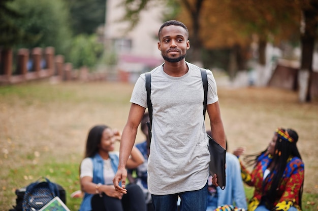 Group of five african college students spending time together on campus at university yard Black afro friends studying Education theme