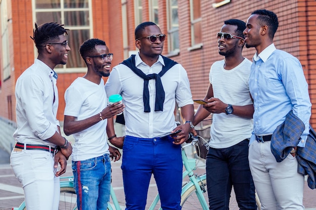 Photo a group of five handsome african american friends of the groom fashionable welldressed businessmen having fun and rest and enjoy in the summer in the park