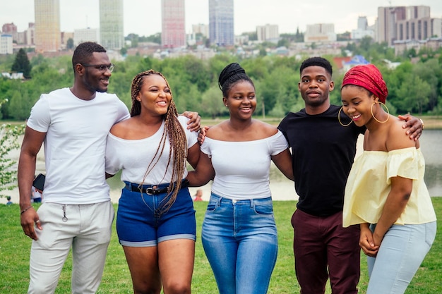 group of five smiling african-american men and women walking outside cloudy weather near the lake,exchange students in Russia