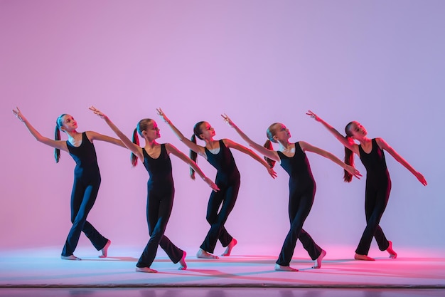 Photo group of five teenagers balrins in black tightfitting costumes are dancing modern konteporari on a l