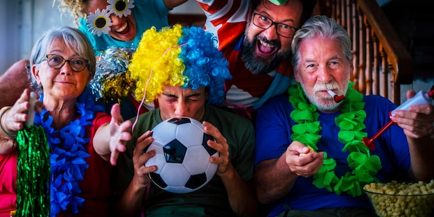 Foto il gruppo di appassionati di calcio a casa si diverte ed esulta per il successo della squadra - concetto televisivo del campionato mondiale 2022 - famiglia che guarda il calcio in televisione a casa e si diverte insieme in amicizia