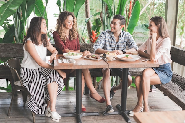 カフェで一緒に昼食をとっている4人の親友のグループ