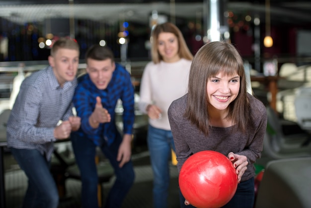 Group of four friends in a bowling alley having fun.